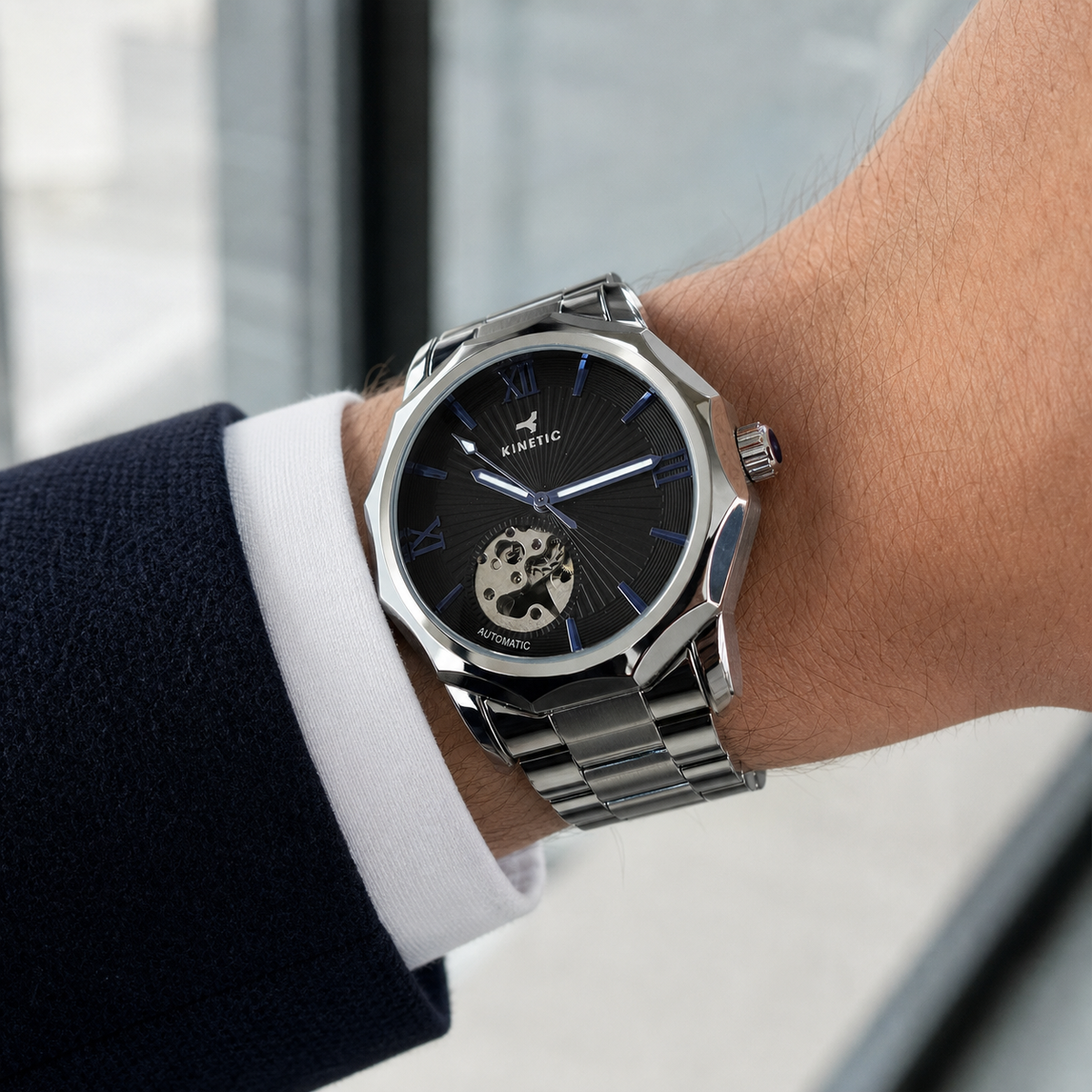 KINETIC Oceana black-dial stainless-steel watch shown beside a navy cuff