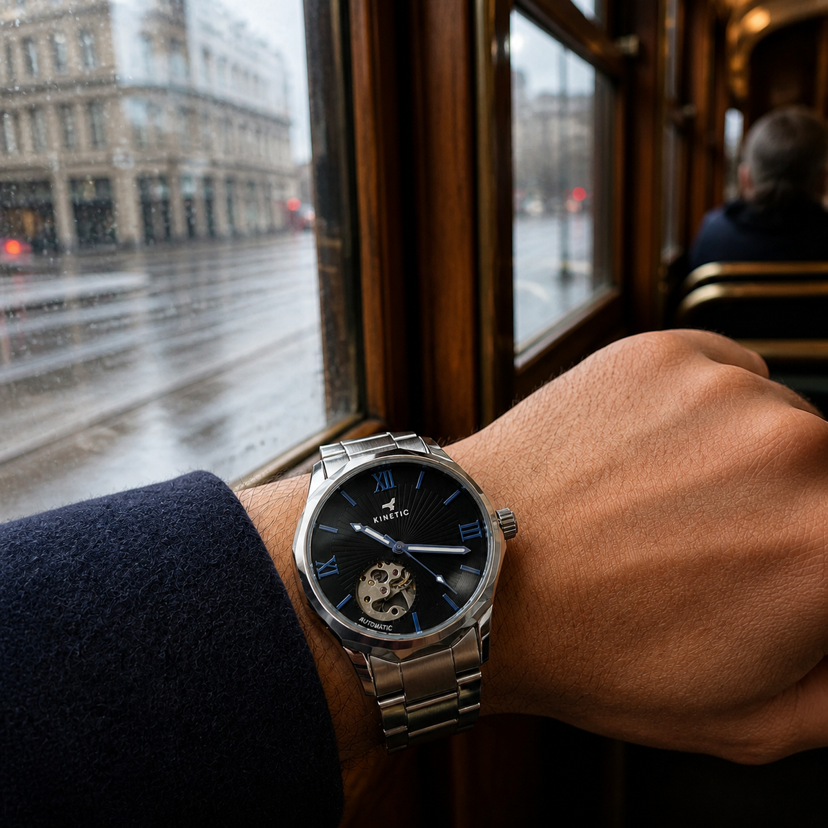 KINETIC Oceana black-dial stainless-steel watch worn during a rainy Melbourne tram commute